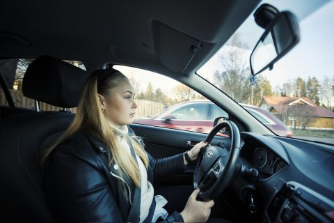 Nuori kuljettaja keskittyy ajamiseen.